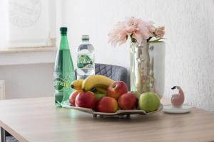 a tray of fruit on a table with a bottle of soda at T&K Apartments near Messe Fair Trade Düsseldorf und Airport 1B in Duisburg +7 photos