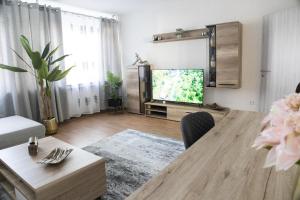 sala de estar con mesa y TV en T&K Apartments near Messe Fair Trade Düsseldorf und Airport 1B, en Duisburg