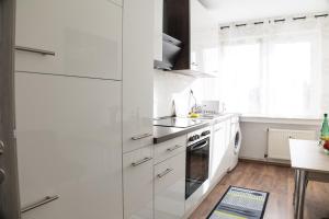 a white kitchen with white cabinets and a window at T&K Apartments near Messe Fair Trade Düsseldorf und Airport 1B in Duisburg