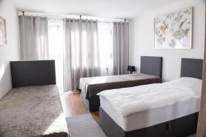 a hotel room with two beds and a window at T&K Apartments near Messe Fair Trade Düsseldorf und Airport 1B in Duisburg