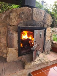 a brick oven with a fire in it at Cal Colina - Karaktervol landhuis met privé zwembad in Pacs del Penedes