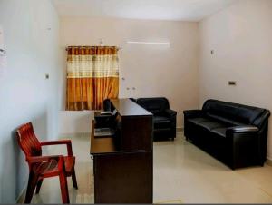 sala de estar con sofá, mesa y sillas en Nandas Grand, en Nellore