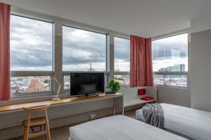 a hotel room with a desk with a computer and windows at Hotel Altus Poznań Old Town in Poznań