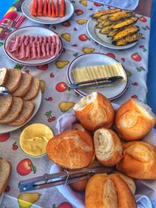 uma mesa coberta com pratos de pão e pastelaria em Pousada Trilha do Sol em Pirenópolis