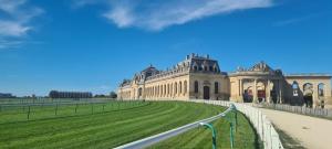 a large building with a green lawn in front of it at Maison tout confort avec jardin - CHANTILLY, SENLIS, PARC ASTERIX, PARIS CDG in Avilly-Saint-Léonard