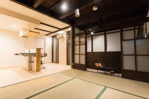 a room with a table and a chair in it at Sanjyomisasagi Umenotoan in Kyoto