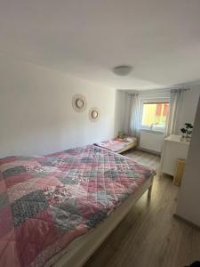 1 dormitorio con 1 cama con edredón en Apartament NAD CZEREŚNIĄ, en Brodnica