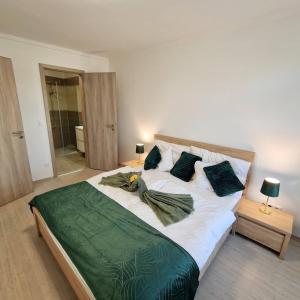 赫維茲的住宿－Hungary Homes Residence II.，卧室配有一张带绿床单和枕头的大床。