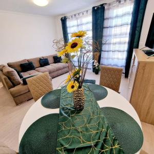 赫維茲的住宿－Hungary Homes Residence II.，客厅配有带向日葵的桌子