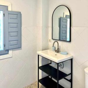 ein Bad mit einem Waschbecken und einem Spiegel in der Unterkunft Casa rural La Casona de Monterrey in Venturada