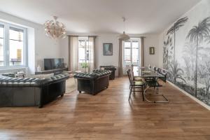 a living room with leather couches and a table at Grande Maison Vichy - Maison ou Appartements en Centre ville in Vichy +30 photos