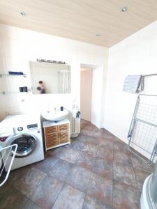 y baño con lavadora y lavamanos. en Gemütliches Zimmer mit eigenem Bad und Küche, en Swisttal