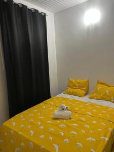 - une chambre avec un lit jaune et une serviette dans l'établissement Pakehina skys, à Schœlcher