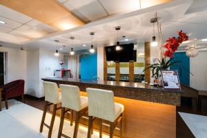 a lobby with a bar with chairs and a television at Festive Hotel in Manila