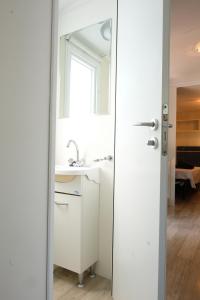 a white bathroom with a sink and a mirror at Happy Camp mobile homes in Camping Village Free Time in Marina di Bibbona