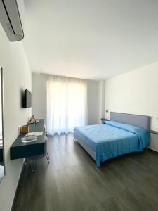 a bedroom with a blue bed and a desk at Casa Lombardi in Santa Maria di Castellabate