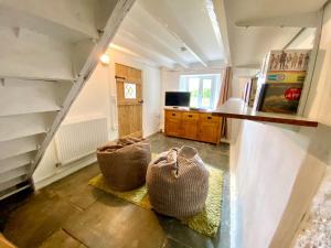 a living room with two baskets on the floor at Badges Cottage for 5 Near Dartmoor Beaches and Pub in Holsworthy