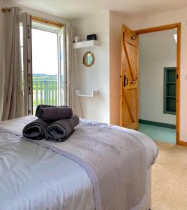 una camera da letto con un letto e asciugamani di Badges Cottage for 5 Near Dartmoor Beaches and Pub a Holsworthy