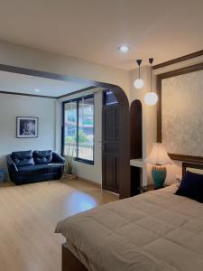 清邁的住宿－October Hostel ChiangMai，一间大卧室,配有一张床和一张沙发