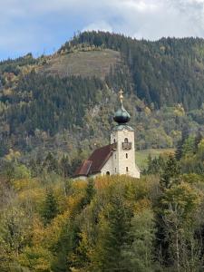 a church on a hill with a cross on top at Apartment zum Bergkircherl - Sommercard in Großsölk