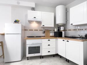 - une cuisine avec des appareils électroménagers et des armoires blanches dans l'établissement 1 Mijas Apartment, à Mijas