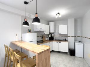 a kitchen with white cabinets and a wooden table at 1 Mijas Apartment in Mijas