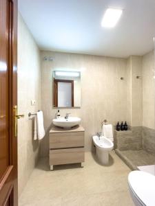 1 Mijas Apartment في ميخاس: حمام مع حوض ومرحاض وحوض استحمام