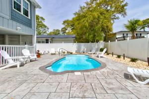 a swimming pool in a yard with chairs and a fence at Ocean Isle Hidden Retreat in Ocean Isle Beach