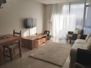 a living room with a tv and a couch and a table at The Quadrant, G505 in Cape Town