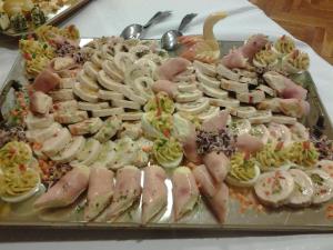 a tray of different types of food on a table at Hotel Magistern Konferencia és WellnessHotel in Siófok