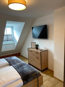 a bedroom with a bed and a tv on the wall at Apartment zum Bergkircherl - Sommercard in Großsölk