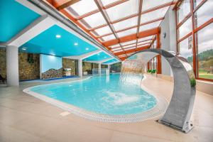 a swimming pool with a fountain in a house at Penzion Josu in Zuberec