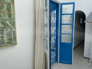 Una puerta azul está al lado de una pared en Chez ADAC, en Sidi Bou Saïd