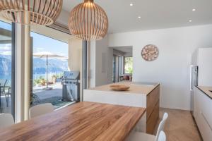 Una cocina con paredes blancas y una mesa y sillas. en Villa Ca' Stella Lake Garda, en Brenzone sul Garda