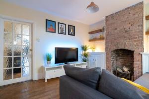 a living room with a couch and a fireplace at Pass the Keys Cosy house with garden in Cheltenham