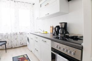 a kitchen with white cabinets and a stove top oven at T&K Apartments near Messe Fair Trade Düsseldorf und Airport 2A in Duisburg +12 photos