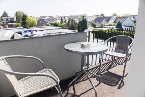 a small table and two chairs on a balcony at T&K Apartments near Messe Fair Trade Düsseldorf und Airport 2A in Duisburg