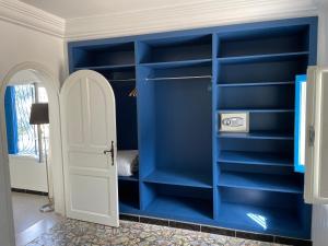 a room with blue shelves and a white door at Chez ADAC in Sidi Bou Saïd