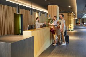 a group of people standing at a counter in an office at Lodge Park Hotel & Spa in Soldeu