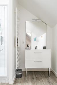 een witte badkamer met een wastafel en een spiegel bij Grande Maison Vichy - Maison ou Appartements en Centre ville in Vichy