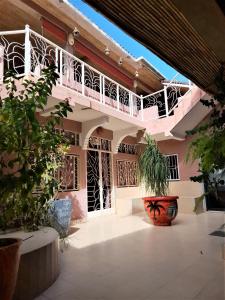 a courtyard of a house with a balcony at Auberge Le Baobab in Saly Portudal