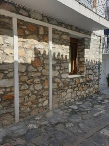 une façade en pierre d'un bâtiment avec une fenêtre dans l'établissement Sofia's Apartment, à Skiathos Chora
