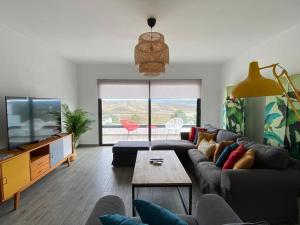 a living room with a couch and a tv at Cairnvillas Villa Flow C40 Luxury Villa with Private Swimming Pool near Beach in Aljezur
