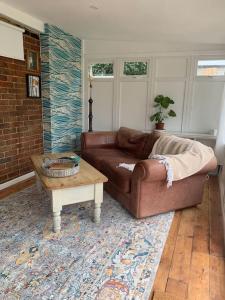 a living room with a couch and a coffee table at Seaside 1 Bed Studio Conversion in Selsey