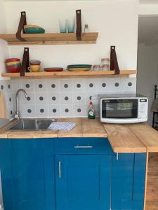 a kitchen with a sink and a microwave on a counter at Seaside 1 Bed Studio Conversion in Selsey