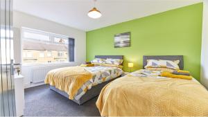 two beds in a room with green walls at Newbiggin House - Newbiggin by the Sea in Woodhorn