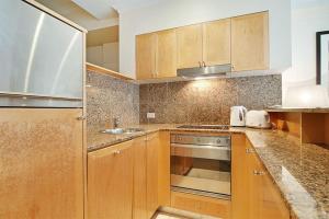 a kitchen with wooden cabinets and a stainless steel appliance at CBD Corporate Apartment BON002810 in Sydney