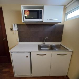 a small kitchen with a sink and a microwave at Bolivian Rooms & Suites (Zona Sur) in La Paz