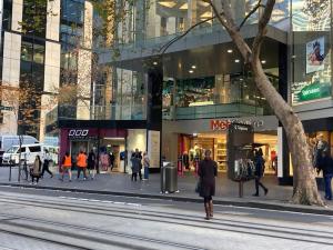 Un groupe de personnes marchant dans une rue d'une ville dans l'établissement CBD Corporate Apartment BON002810, à Sydney