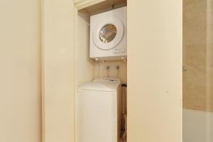 een wasmachine en droger in een witte kamer met een raam bij CBD Corporate Apartment BON002810 in Sydney